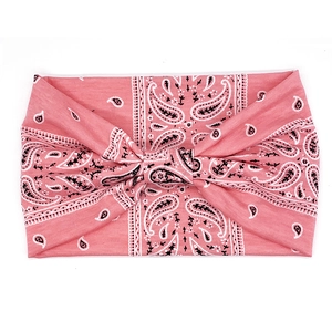 Detail of pink bohemian paisley headband with a central twist knot on white backdrop