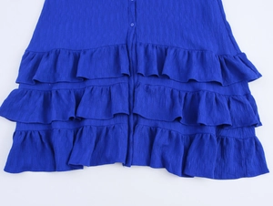 Details des gestuften Rüschensaums und der Plisseestruktur bei einem blauen Kleid