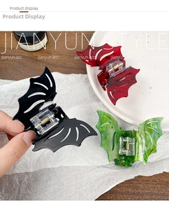 Detail of gothic bat hair claws in black, red, and green marble textures with metal spring