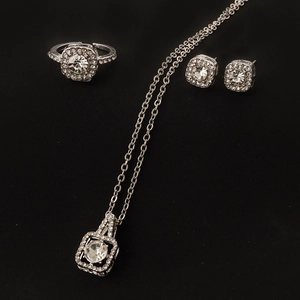 Three-piece silver jewelry set with zircon necklace, earrings and ring on black background