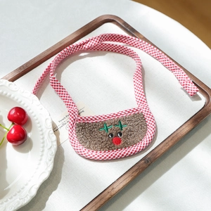 Detail view of red plaid Christmas dog bandana with plush reindeer on a wood tray