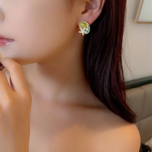 Enamel ocean style starfish earrings with green glaze and pearls worn by a model