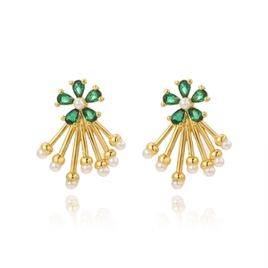 Detail view of gold flower earrings with green crystals and long pearl tassels