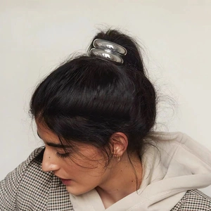 Close-up of a silver metallic chain hair ring accessory for high ponytail styling