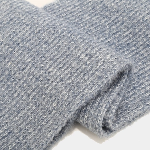 Detailed close-up of blue and white mixed knit fabric showing thick thermal texture