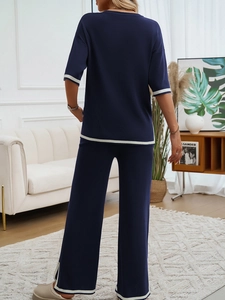Vue arrière d'un ensemble en tricot bleu marine avec rayures blanches et pantalon large