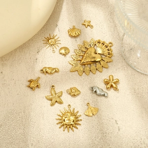 Flat lay of gold and silver charms featuring starfish, hearts and sea turtle pendants