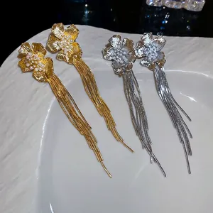 18k gold plated flower tassel earrings with pearls on a white decorative plate