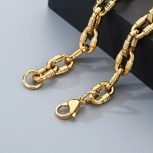 Detail of heavy gold O-chain bracelet with textured rings and lobster clasp closure
