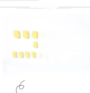 Vue détaillée de 24 faux ongles jaune macaron de forme carrée sur un fond blanc neutre