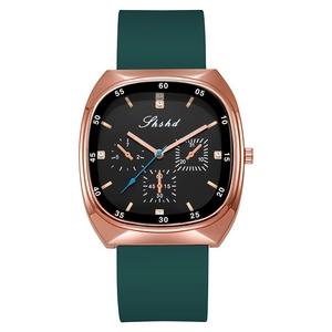 Macro detail of rose gold watch case with dark green silicone strap and chronograph dial