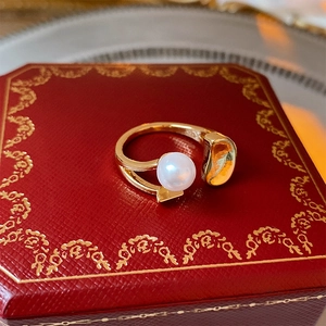 Detail shot of a minimalist gold pearl open ring showcasing the organic geometric design