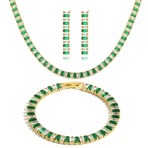 Detail of emerald green and white baguette-cut stones in gold jewelry set