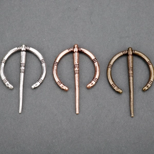 Three Viking metal penannular brooches in silver, copper, and bronze finishes for capes