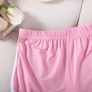 Detail of pink sports shorts showing elastic waistband and side white stripes