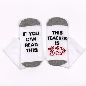 Detailed view of white cotton socks with funny text on soles showing off duty teacher