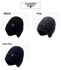Gros plan de bonnets en tricot épais montrant des écussons flocon en noir, gris et bleu