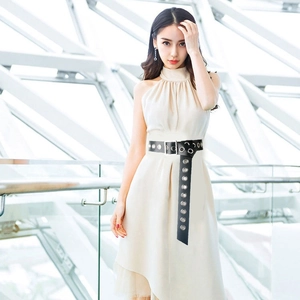 Women's black wide PU leather belt with metal eyelets and square buckle on beige dress