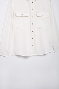 Detail of white crepe shirt showing gold buttons and functional chest flap pockets