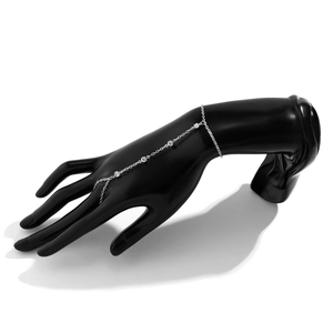 Close-up of silver-tone hand chain bracelet with rhinestones on a black mannequin hand