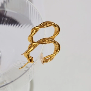 Close-up of golden stainless steel hoop earrings with elegant twisted rope texture