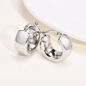 Close-up of polished silver hollow hoop earrings with classic square tube geometric design