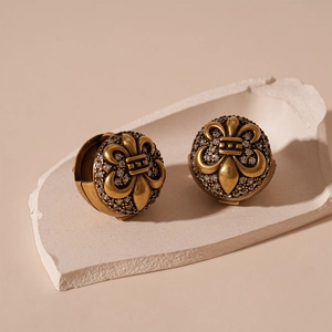 Detail of vintage gold ball earrings featuring iris patterns and zircon insets