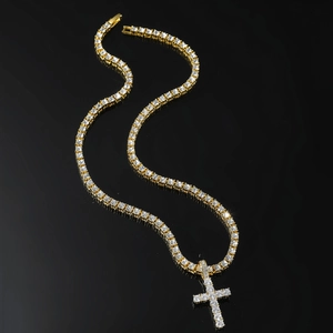 Gold tennis necklace with a cross pendant and sparkling stones on a sleek black background