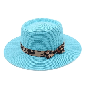 Detail of sky blue boater hat featuring woven straw texture and leopard print ribbon