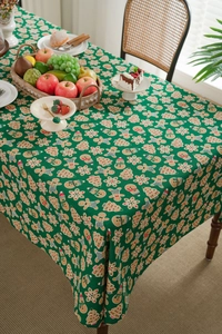 Festive green tablecloth with gingerbread man patterns creating a warm Christmas atmosphere
