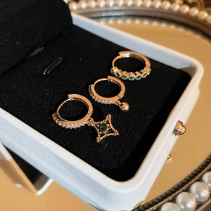 Set de trois boucles d'oreilles créoles dorées avec étoiles vertes et zircons étincelants