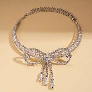Detail of silver bowknot tassel necklace with rhinestones and imitation pearls