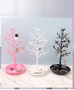 Three bird tree jewelry stands in pink, white, and black colors for necklace display