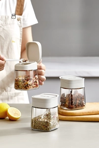 Detail of three thickened lead-free glass spice jars with integrated spoons and airtight lids