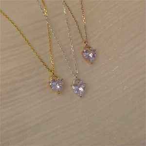 Detailed view of heart-shaped pendant necklaces in gold, silver, and rose gold finishes