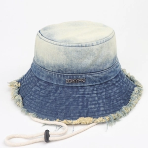 Détail d'un bob en denim dégradé avec bords effilochés et cordon de serrage réglable