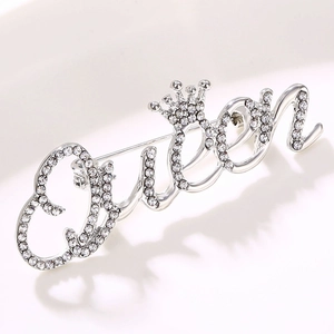 Elegant silver Queen brooch with crown design and sparkling rhinestones on white background