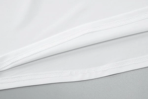 Detail view of double-needle stitching on white fabric hem of a summer beach dress set