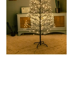 Detail of warm white LED lights on black artificial birch tree for festive home decoration