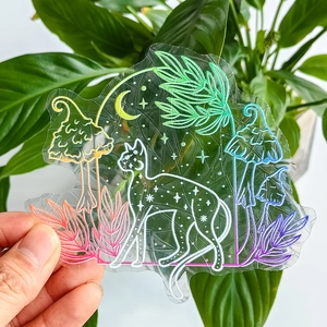 Detailed view of suncatcher sticker with cat and mushroom patterns creating rainbow light