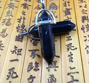 Macro detail of hexagonal black agate stone pendants with silver metal clasps on bamboo
