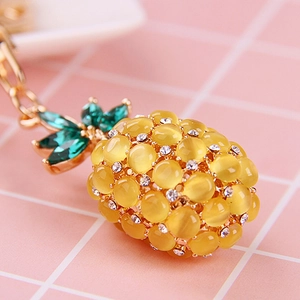 Detailed close-up of opal pineapple keychain with yellow beads and green leaves embellishments