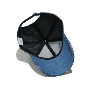 Detail view of denim baseball cap interior featuring breathable black mesh and logo tag