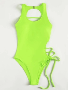 Close-up of side cutouts and cross strap details on neon green one-piece swimsuit