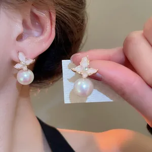 Boucles d'oreilles fleurs en émail rose et perles portées par un mannequin rétro