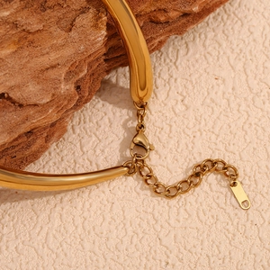 Detailed close-up of 18K gold plated bamboo link necklace with lobster clasp on rock