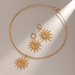 Macro detail of 18k gold stainless steel sunflower collar and spiral earrings set