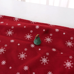 Red Christmas table runner with white snowflake patterns and festive textile texture