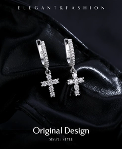 Detailed view of S925 silver cross drop earrings with pavé stones on black leather