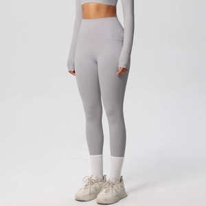 Detail of high-waist light grey yoga pants featuring functional side pockets and elastic fabric